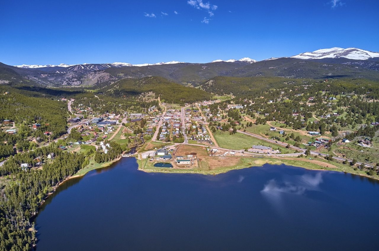 Aerial view west over Nederland, Colorado, with Barker Reservoir below the snow-capped Continental Divide